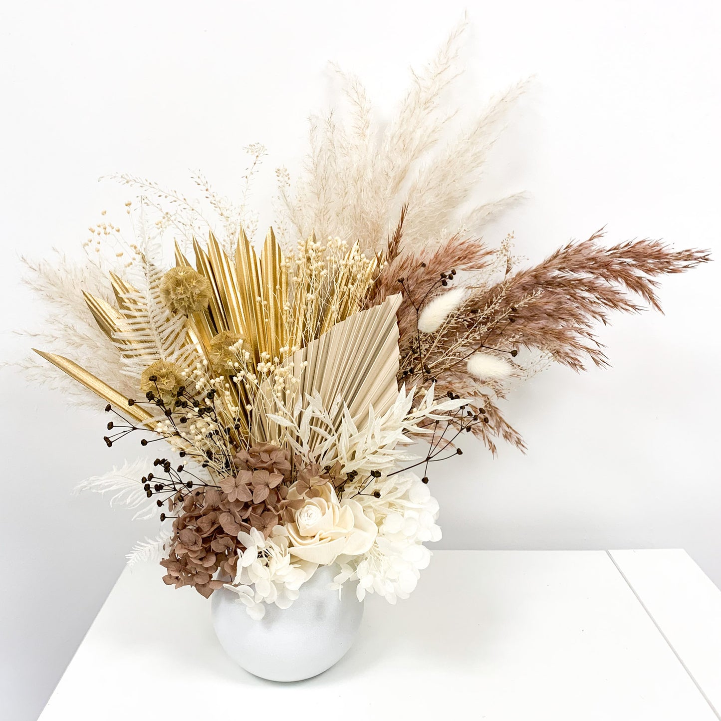 neutral and gold flower arrangement in pot