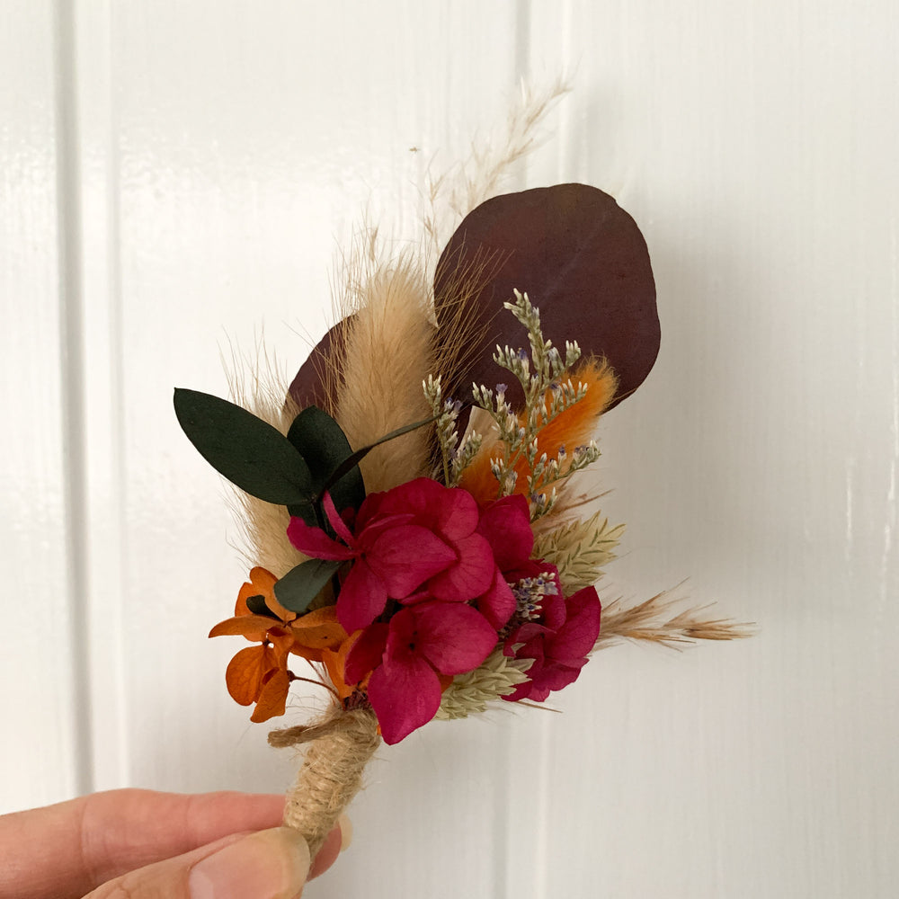 
                      
                        Burnt Orange and Cherry Dried Flower Buttonhole
                      
                    