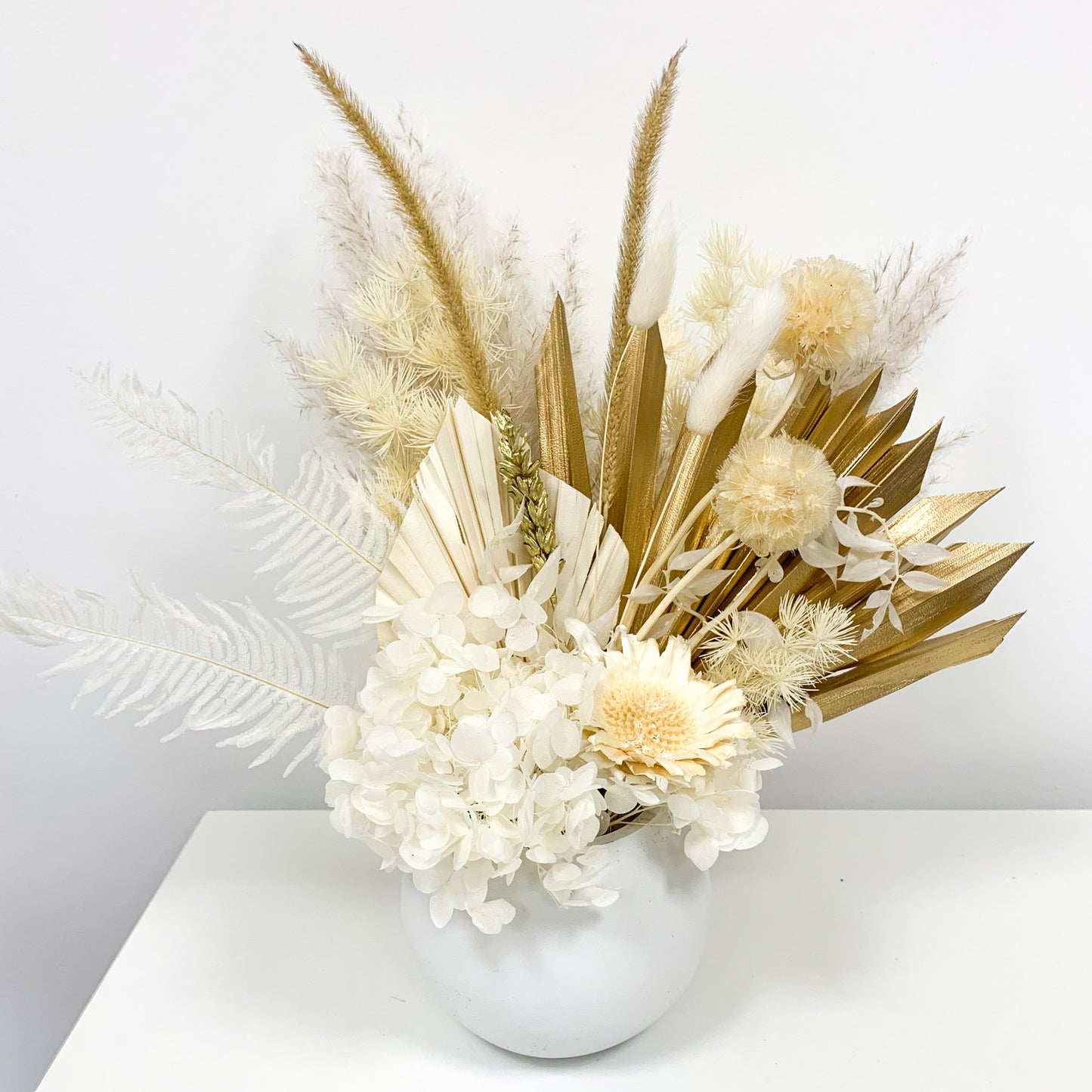 white flower arrangement with gold