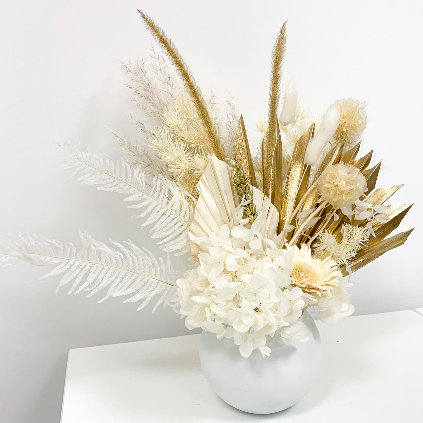 gold and white dried flower arrangement